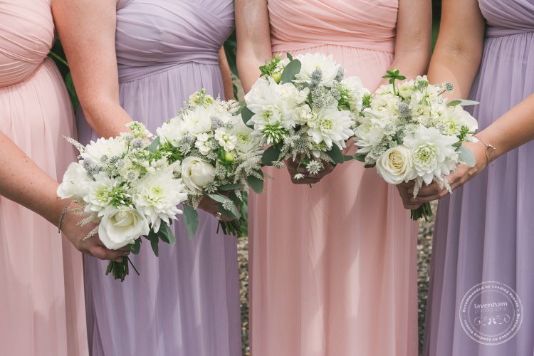 Photography of the bridemaids' wedding bouquet's before the wedding ceremony at Preston Priory Barn. Alternating bridemaids dress colours