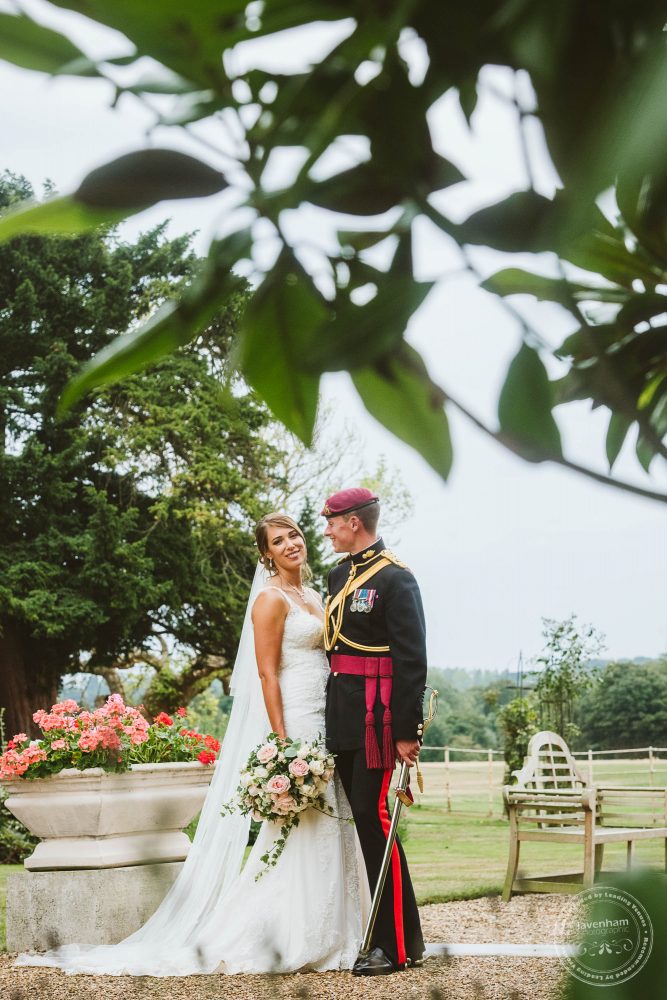 Photograph of the Bride and groom, framed with leafy foliage at the top of the frame