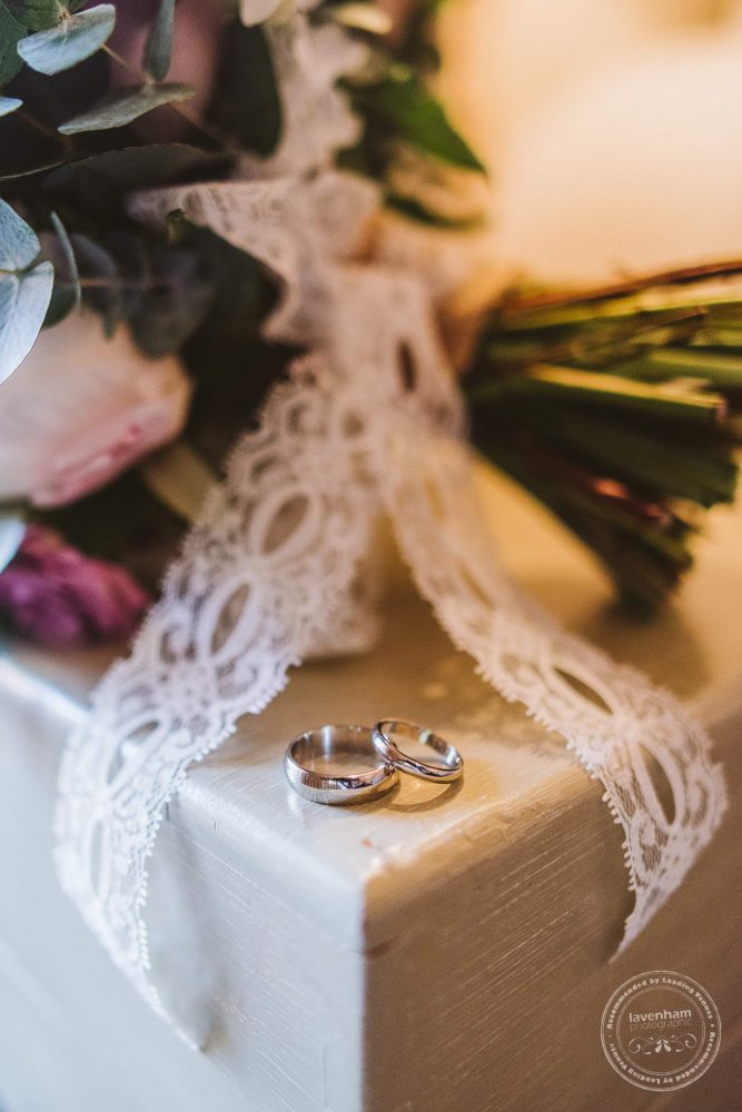 Detail photography of the wedding rings with lace from the bride's bouquet
