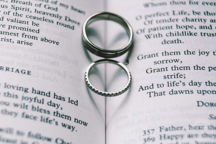 Wedding rings on hymn book, making heart shapes with their shadows