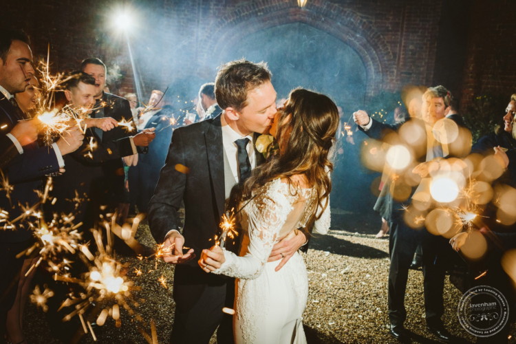 Bride and groom kiss with sparklers