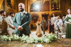 A joyful bride enters the church with her father, as guests watch and smile during their wedding ceremony in a stunning, historic venue in Essex and Suffolk. Elegant wedding ceremony inside a historic church in Essex and Suffolk, with the bride walking down the aisle surrounded by family and friends, captured in a beautifully lit, atmospheric setting.