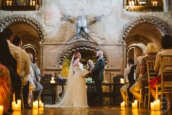 A romantic wedding vows exchange at a rustic Essex barn, featuring atmospheric candlelight, historical decor, and a charming ambiance for a memorable ceremony. Elegant wedding ceremony in historic Essex barn with rustic candles, medieval decor, and a couple exchanging vows under atmospheric lighting.